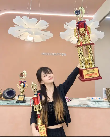 HOWMAY 好美的學員在工作室裡手舉美睫總冠軍獎盃